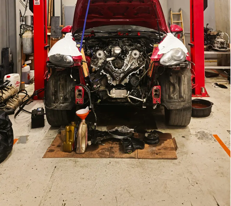 Auto repair bay with a red lift over oil-stained, worn bare concrete (stock photo)