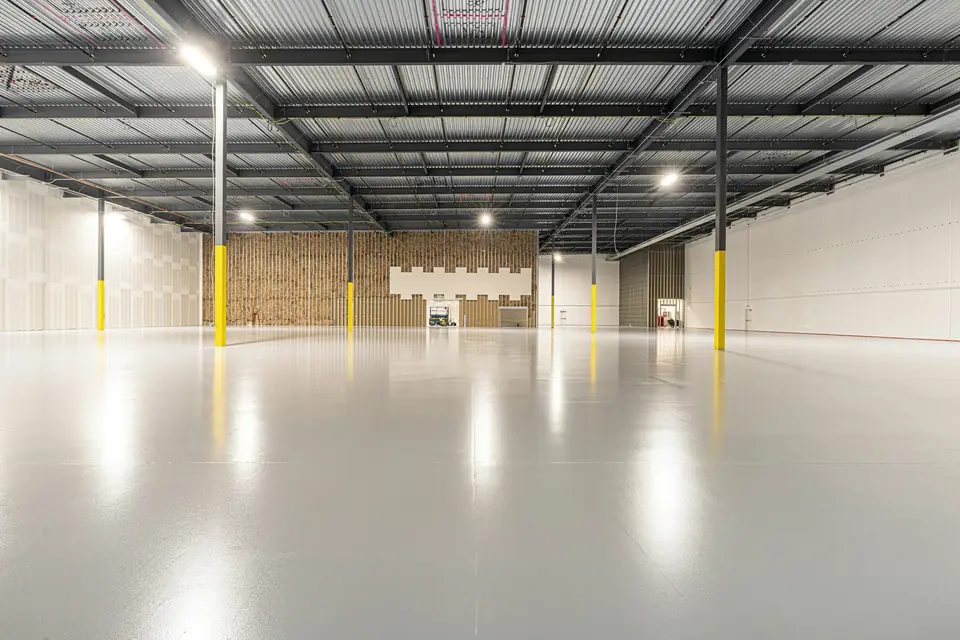 The same kind of concrete slab after a gray epoxy floor coating, smooth and reflective (stock photo)