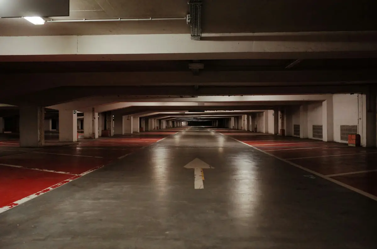 Red floor coating worn and chipped through to concrete in the traffic lanes of a parking deck (stock photo)